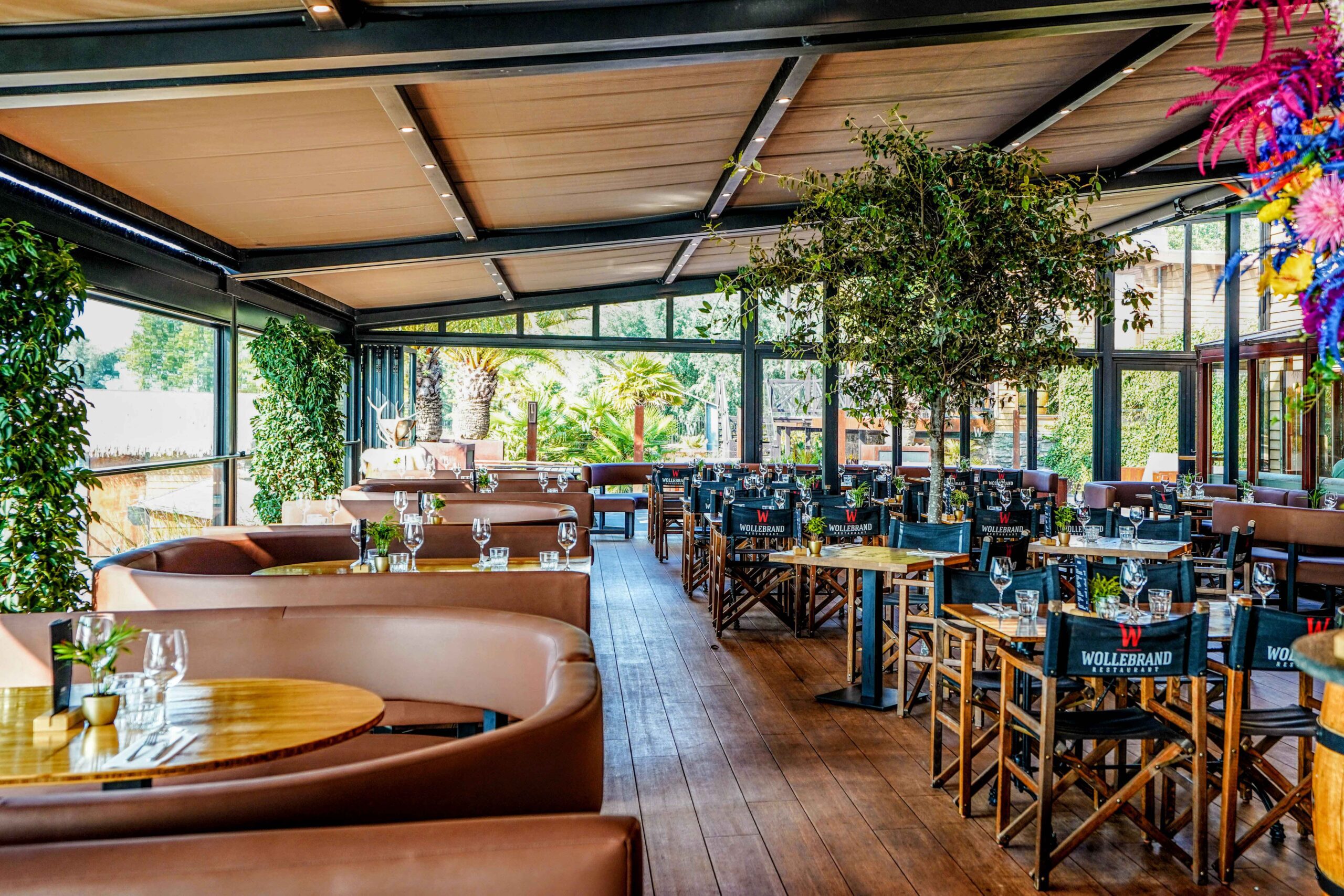 Vierseizoenen serre met doeksysteem – Wollebrand Lakehouse Interieur van horeca serre met gesloten doeksysteem en glazen wanden bij Wollebrand Lakehouse