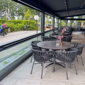 Horecaterras met glazen schuiframen en uitzicht op buitenruimte bij Golfbaan Delfland