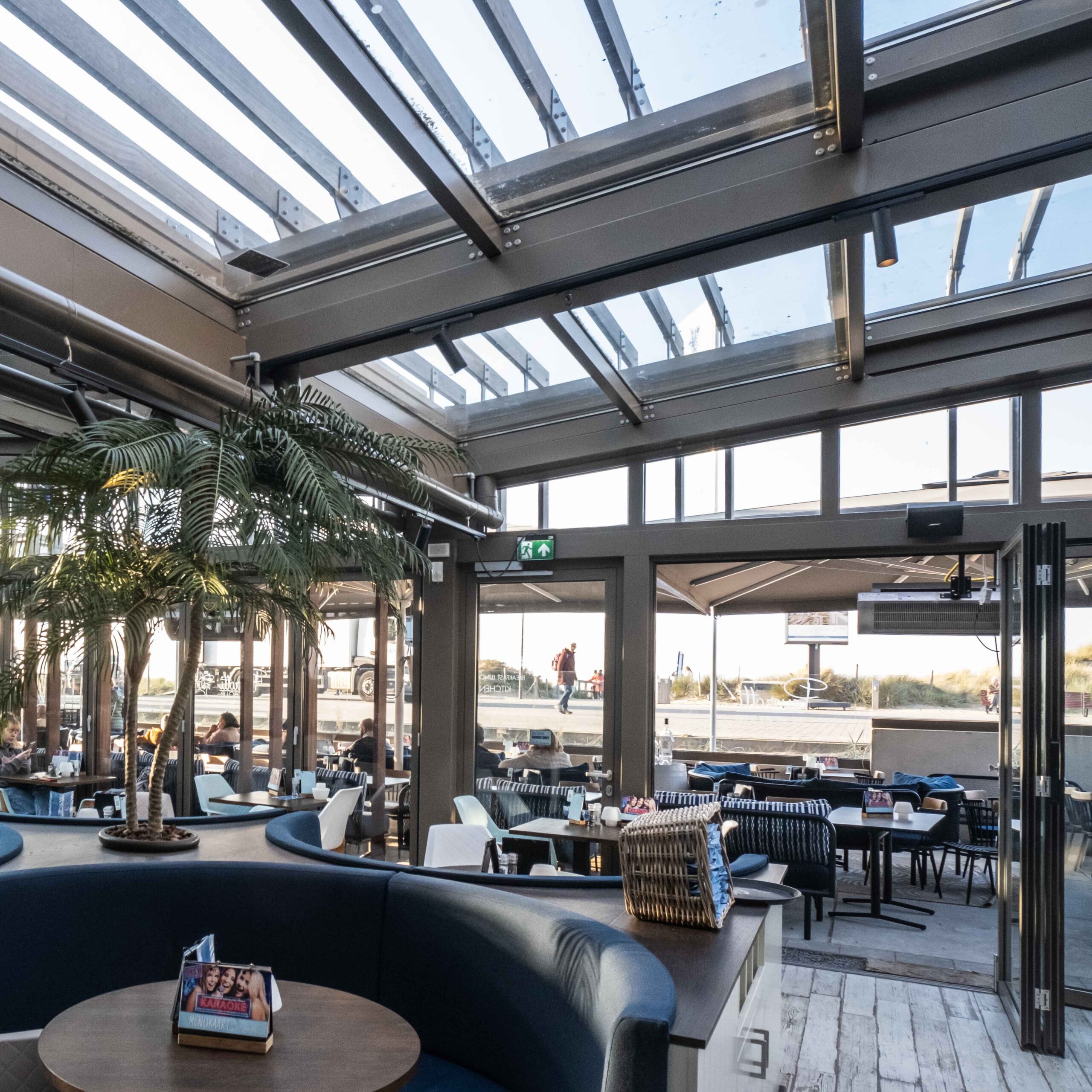 Open elektrisch glazen schuifdak boven horeca terras in Nieuw Kijkduin